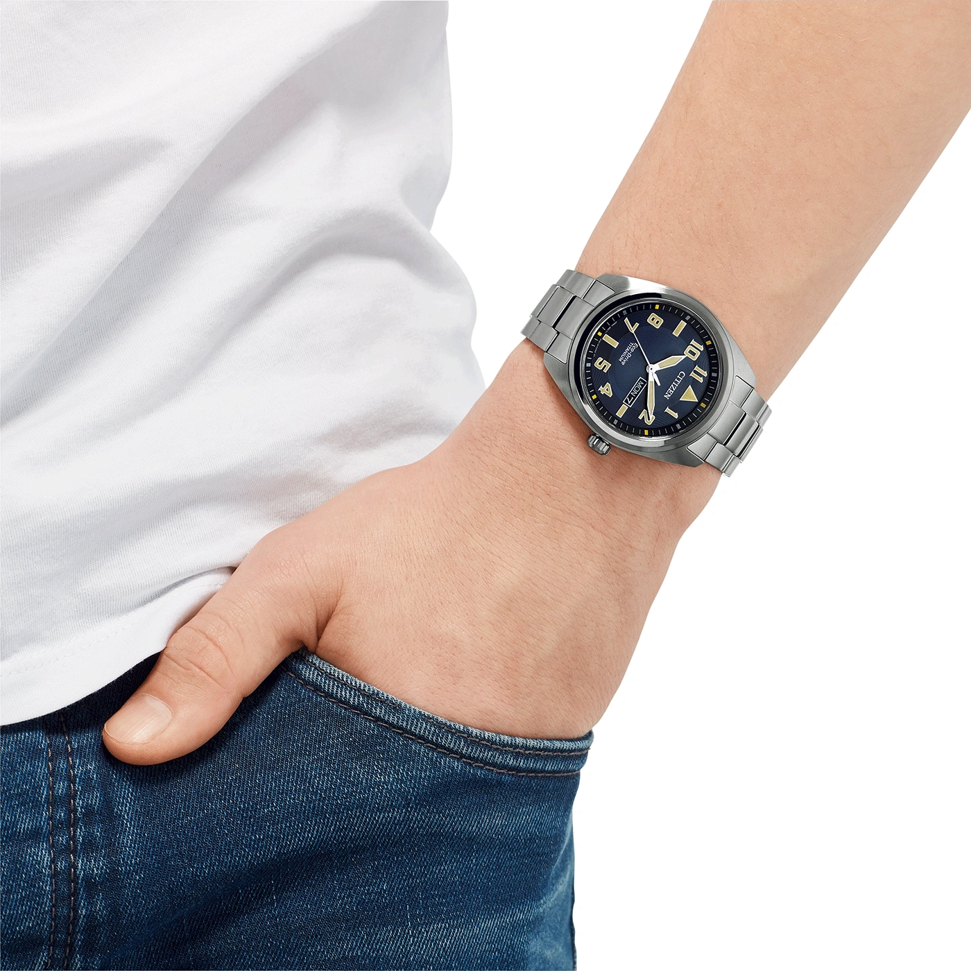 Mann mit Citizen-Uhr, blaues Zifferblatt, Edelstahlarmband, Jeans und weißem Hemd.