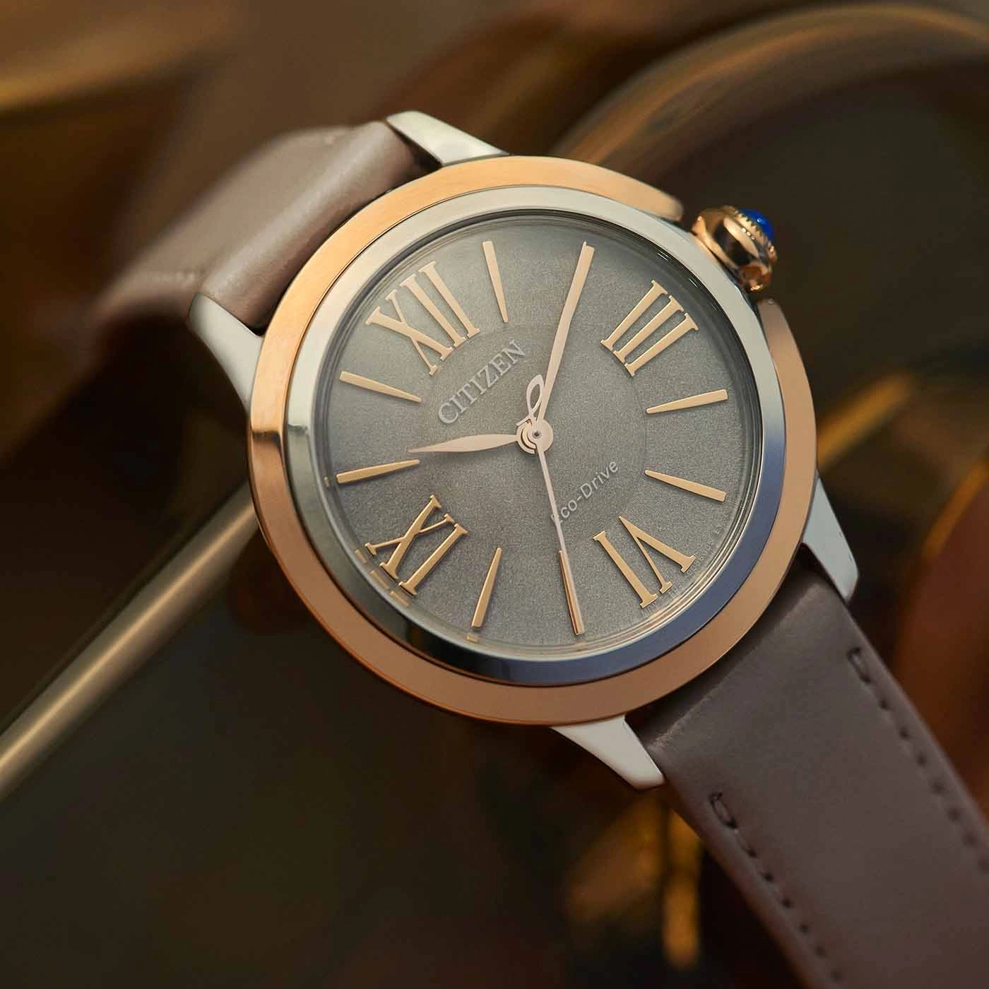Citizen-Uhr mit grauem Zifferblatt, römischen Ziffern und Lederarmband.
