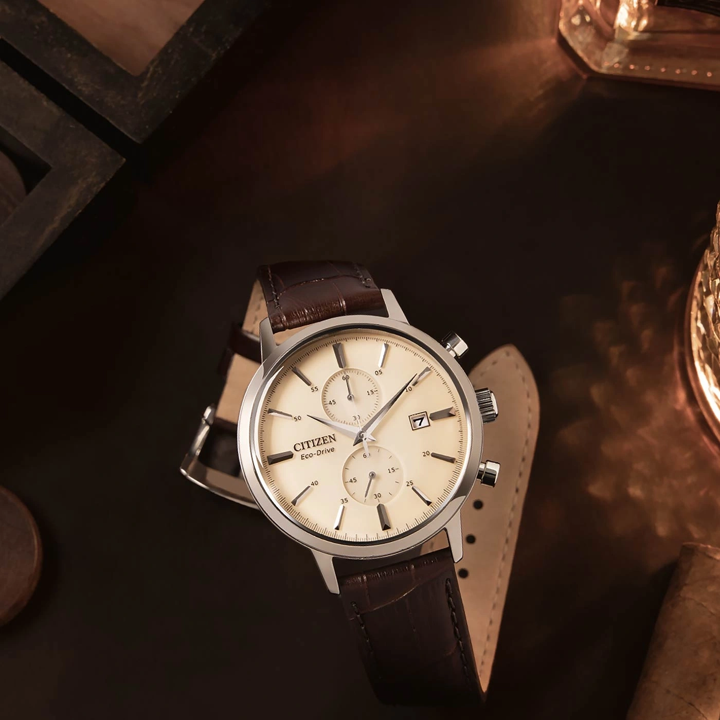 Citizen Eco-Drive Uhr mit braunem Lederarmband auf dunkler Oberfläche.