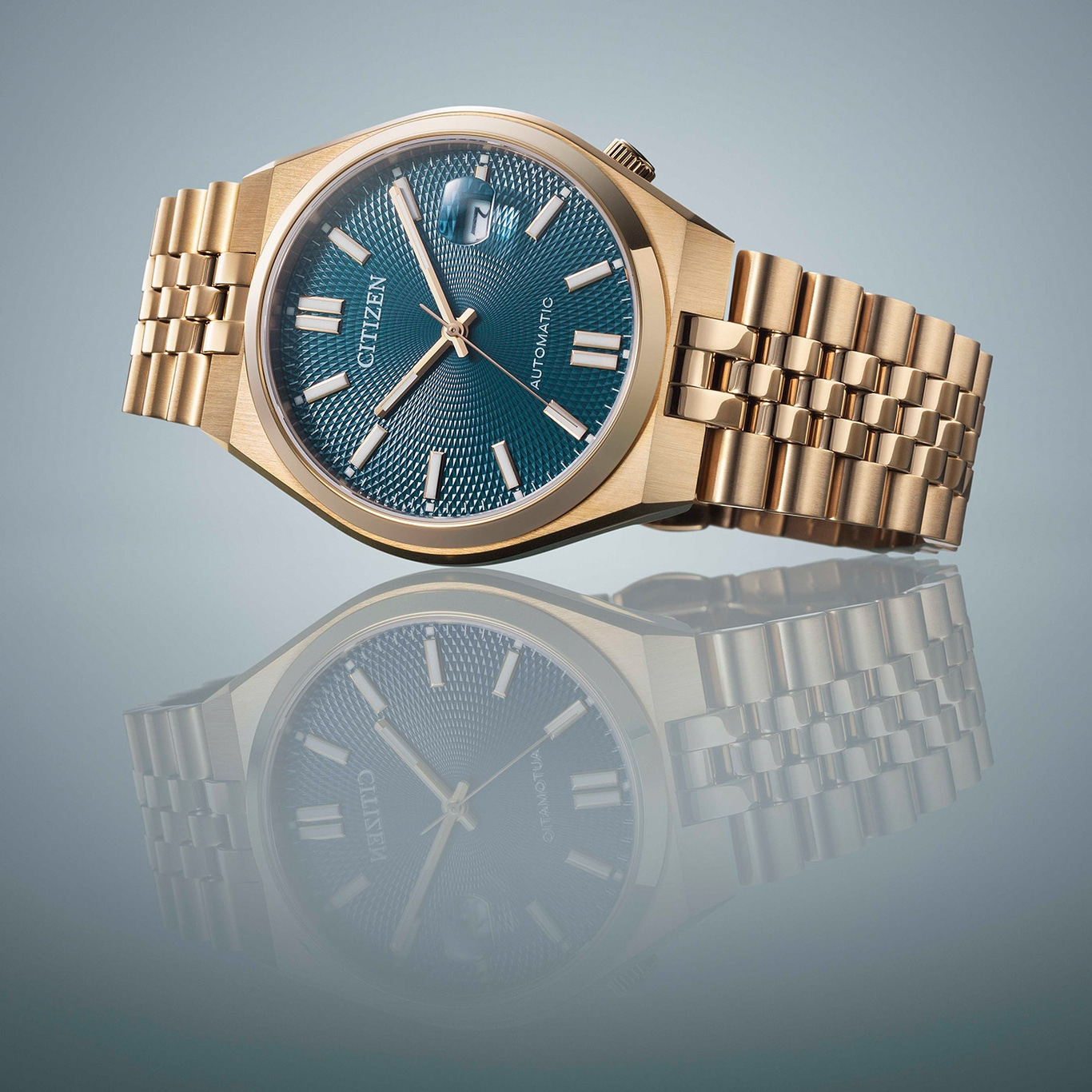 Goldene Citizen-Uhr mit blauem Zifferblatt und Spiegelung auf Oberfläche.