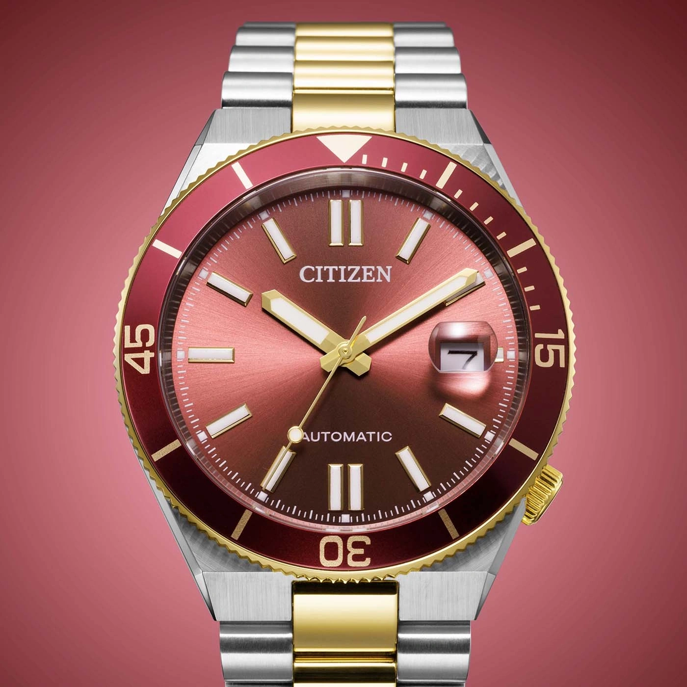 Nahaufnahme einer Citizen Automatik-Uhr mit rotem Zifferblatt und goldenen Akzenten.