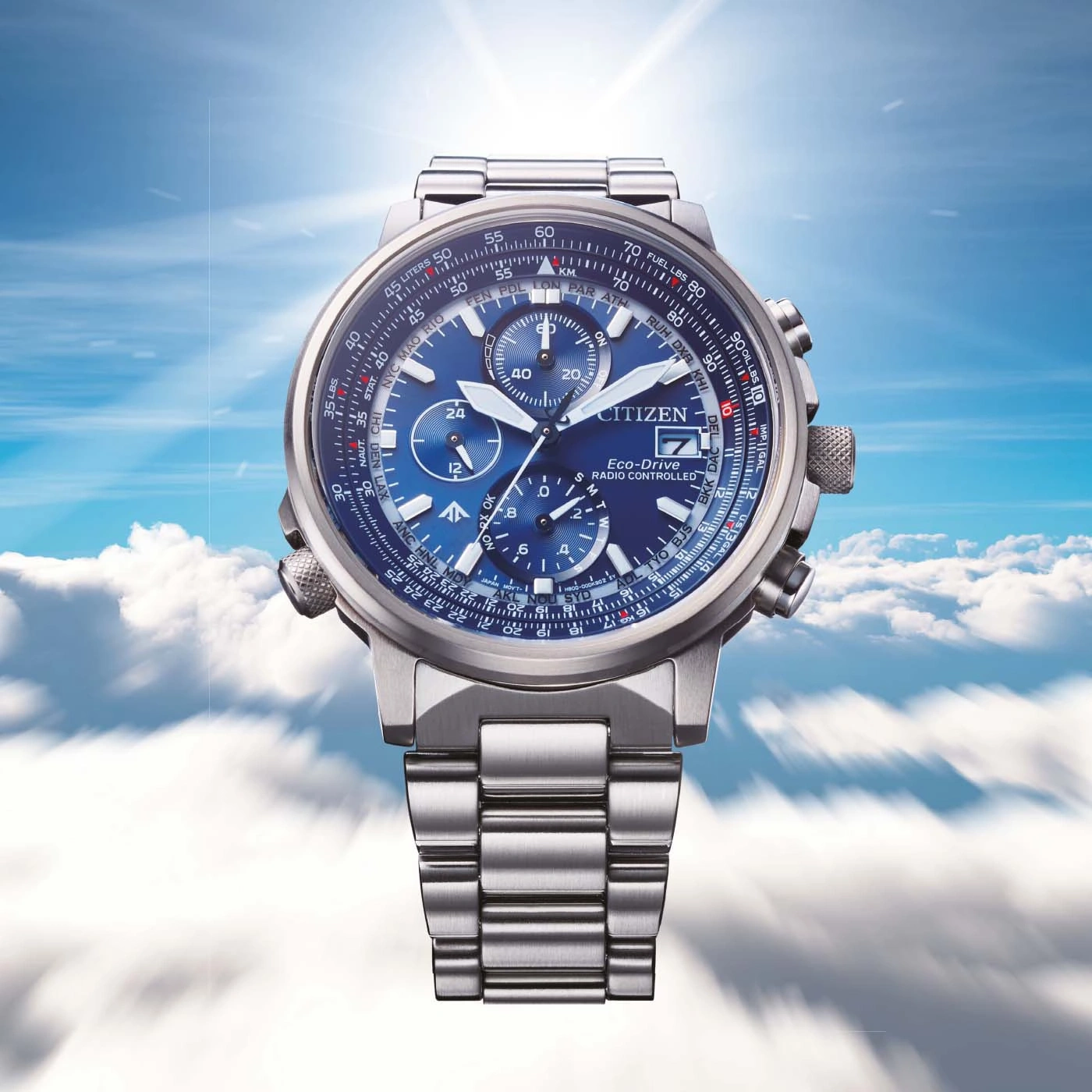 Citizen-Uhr mit blauem Zifferblatt, Edelstahlband und Himmels Hintergrund.