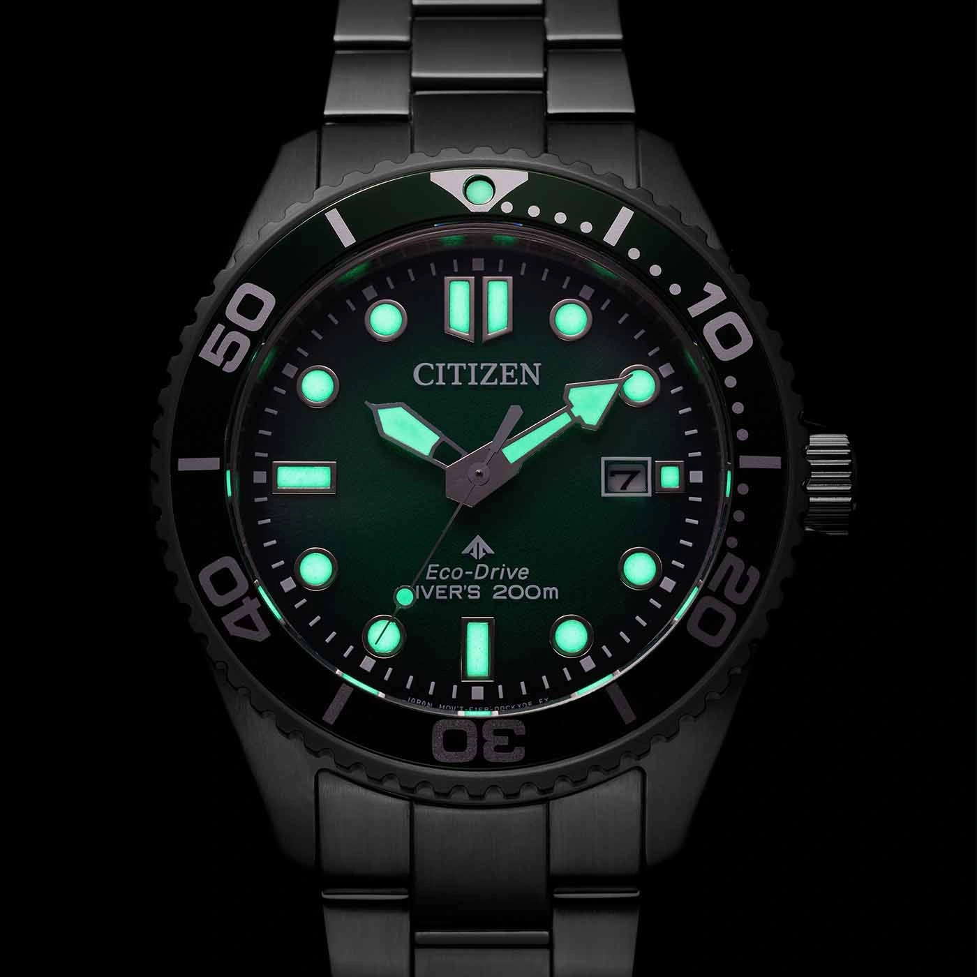 Citizen Eco-Drive Taucheruhr mit grün leuchtendem Zifferblatt und schwarzem Armband.
