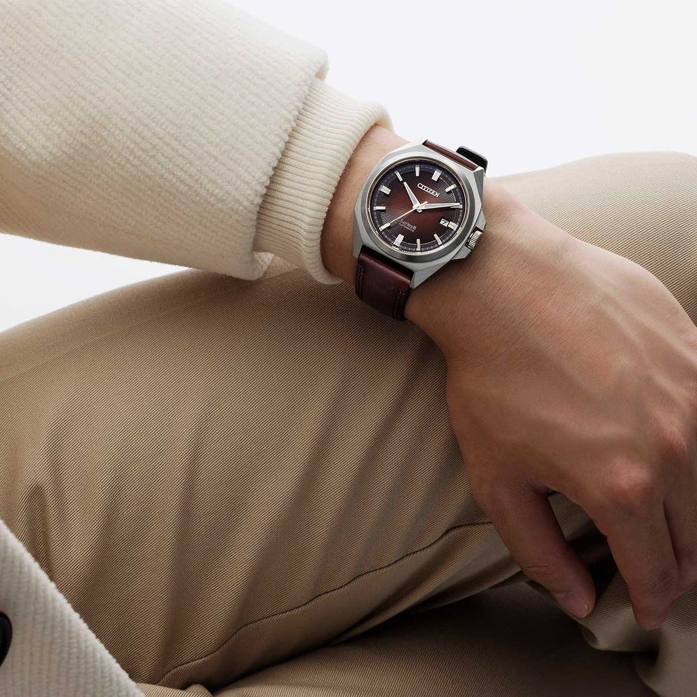 Mann trägt Citizen-Uhr mit braunem Lederarmband und braunem Zifferblatt.