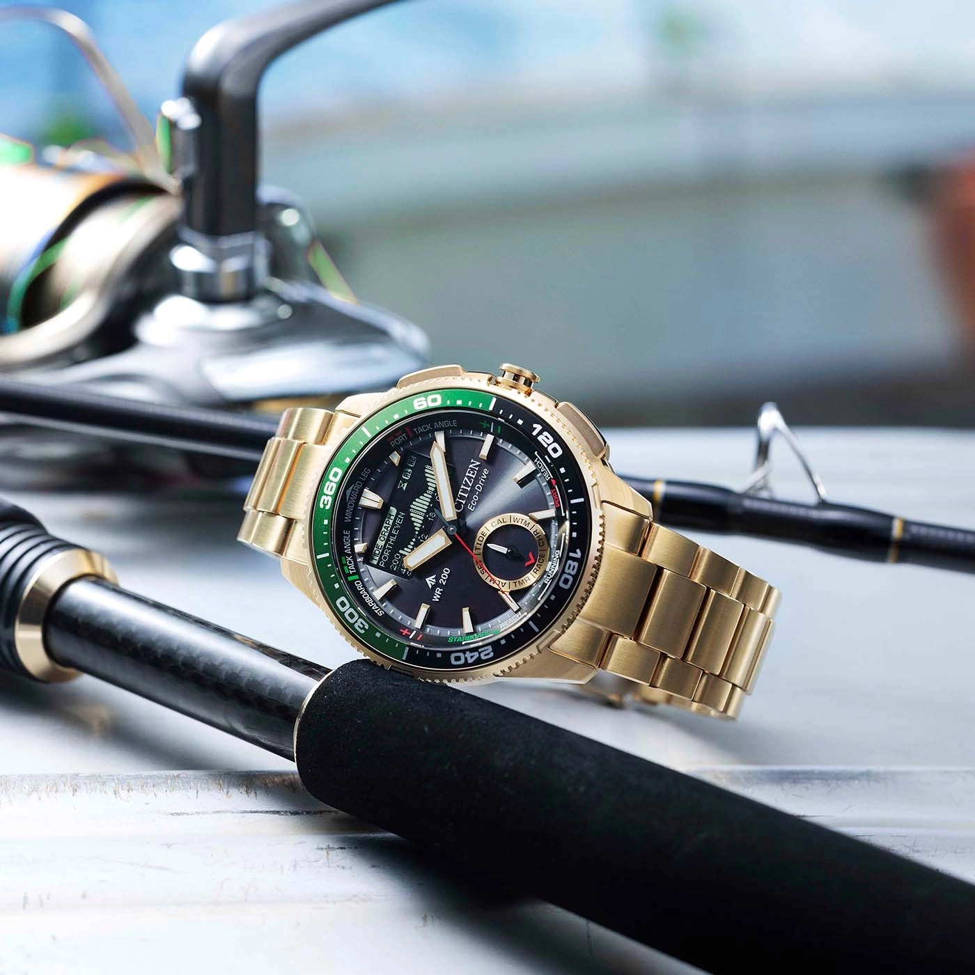Eine goldene Citizen Eco-Drive Uhr liegt auf Angelruten.