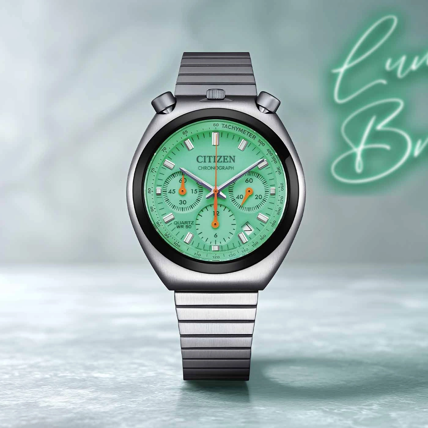 Eine Vintage Citizen Chronograph Uhr mit grünem Zifferblatt und silbernem Band.