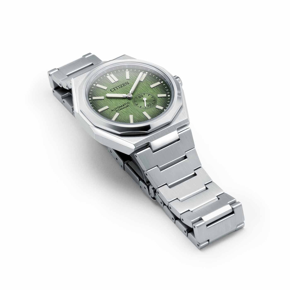 Citizen-Uhr mit grünem Zifferblatt und silbernem Armband auf weißem Hintergrund
