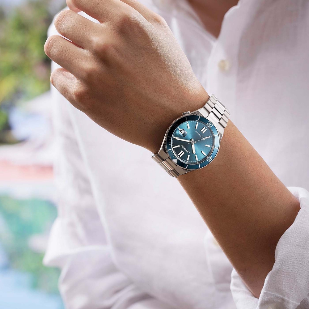 Mann trägt eine blaue Citizen Automatik-Uhr am Handgelenk.