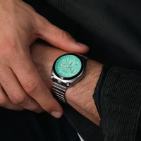 Ein Männerhandgelenk zeigt eine mintgrüne Citizen-Chronographenuhr mit Edelstahlarmband.