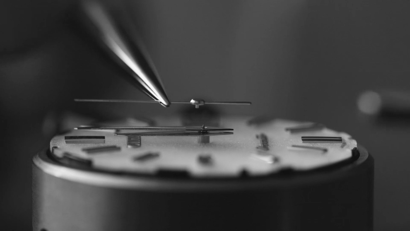 Nahaufnahme des Zusammenbaus eines Uhrenmechanismus mit Präzisionswerkzeugen.