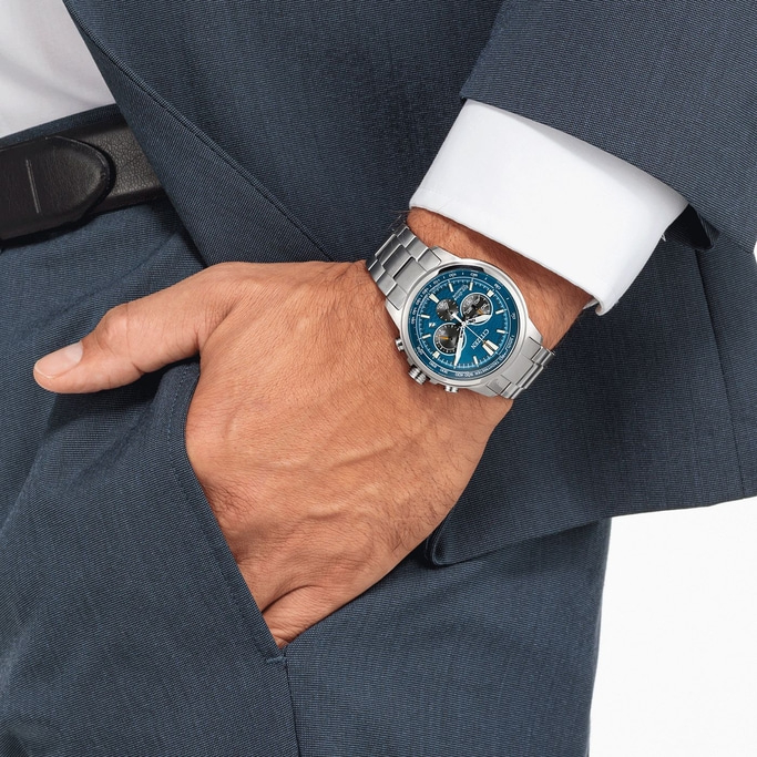 Mann mit blauer Uhr, blauem Anzug und weißem Hemd, Hand in der Tasche.