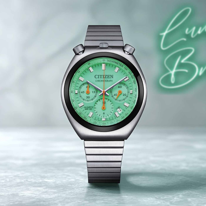 Eine Vintage Citizen Chronograph Uhr mit grünem Zifferblatt und silbernem Band.