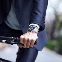 Mann mit Uhr fährt Fahrrad, Nahaufnahme. Stilvolles Accessoire am Handgelenk.