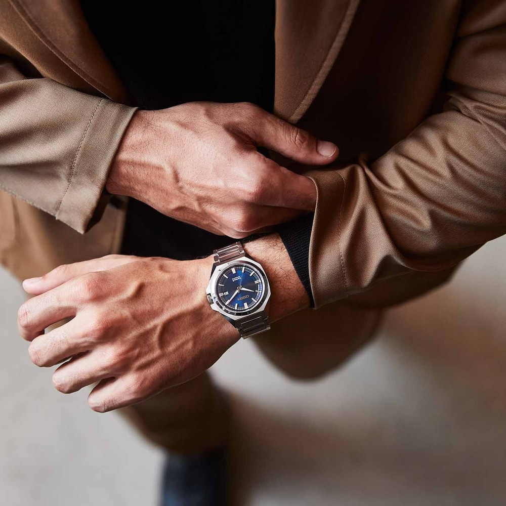 Mann trägt Uhr, Hände auf brauner Jacke, Nahaufnahme