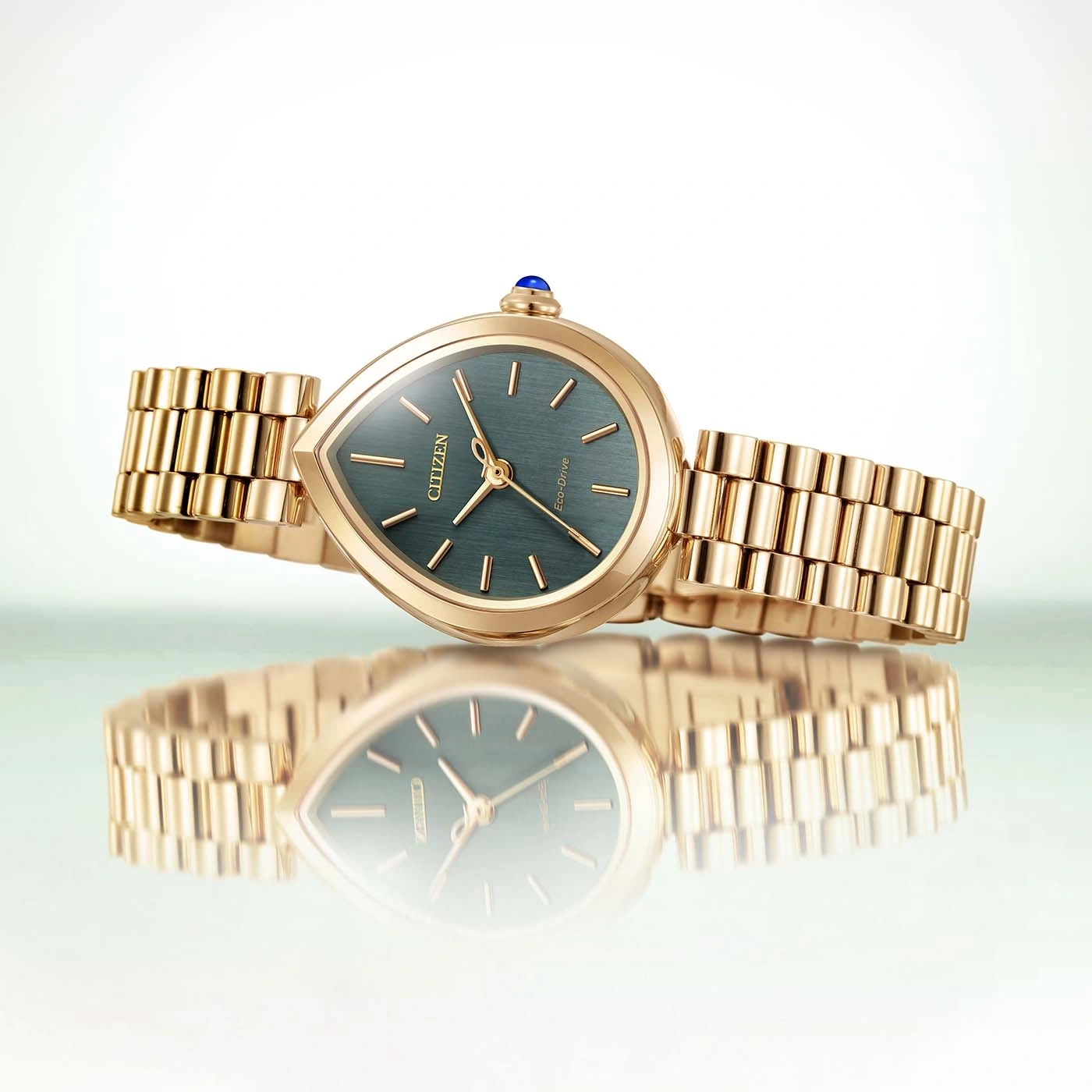 Eine goldene Citizen Eco-Drive Uhr mit tropfenförmigem Zifferblatt und grünem Zifferblatt.