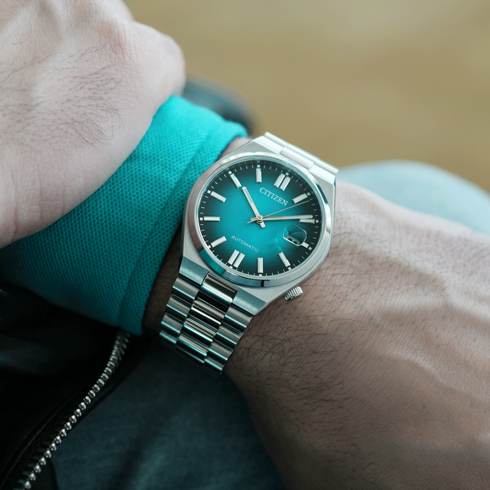 Citizen-Uhr am Handgelenk, türkisfarbenes Zifferblatt, silbernes Armband, Automatikwerk