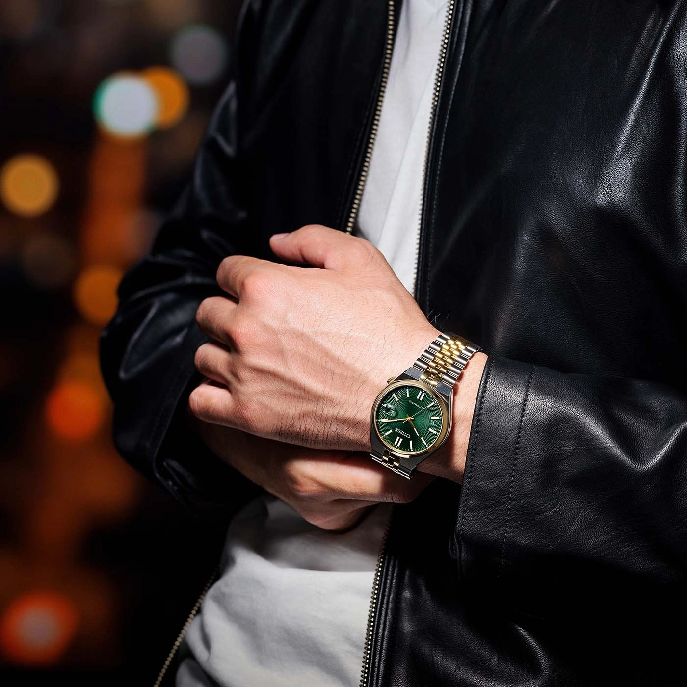 Mann mit Uhr mit grünem Zifferblatt und Gold- und Silberband