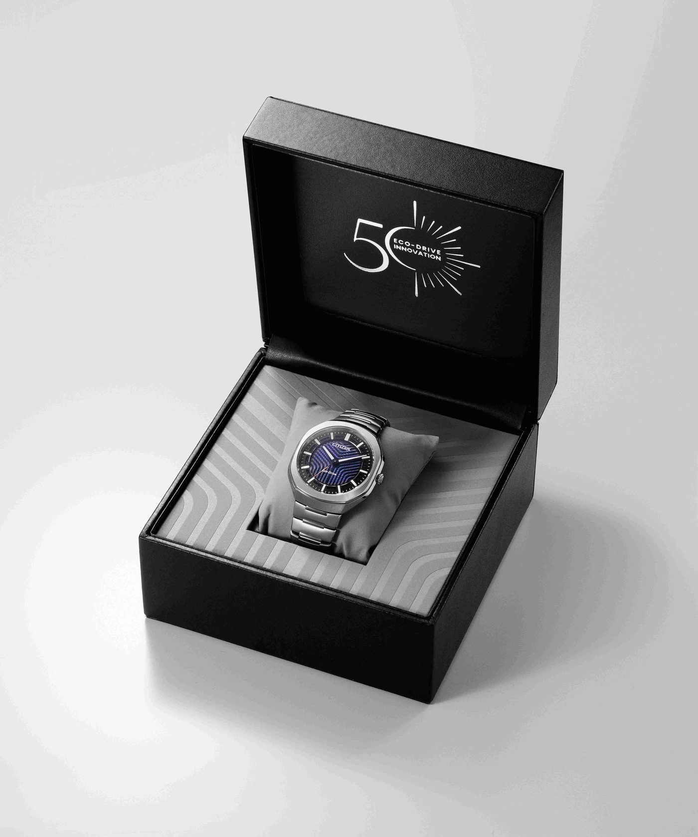 Eine silberne Citizen Eco-Drive Uhr in einer offenen schwarzen Box mit 50-Jahre-Jubiläumslogo.