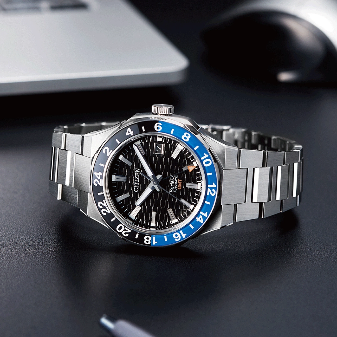 Citizen-Uhr mit schwarzer und blauer Lünette, Edelstahlarmband und GMT-Funktion.