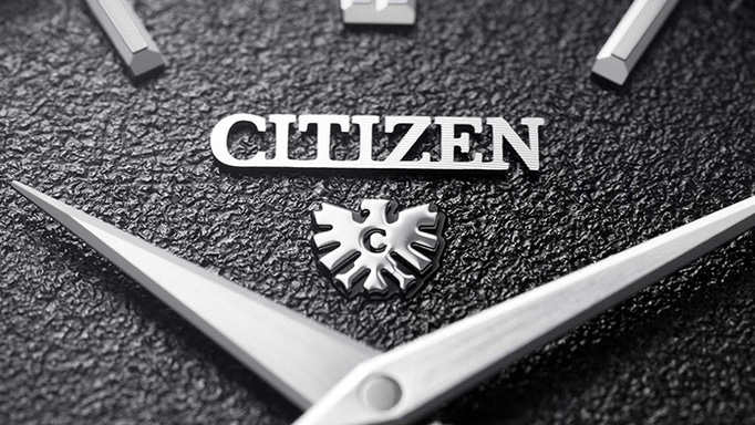 Detailaufnahme einer Citizen-Uhr mit strukturiertem Zifferblatt und Adler-Logo.