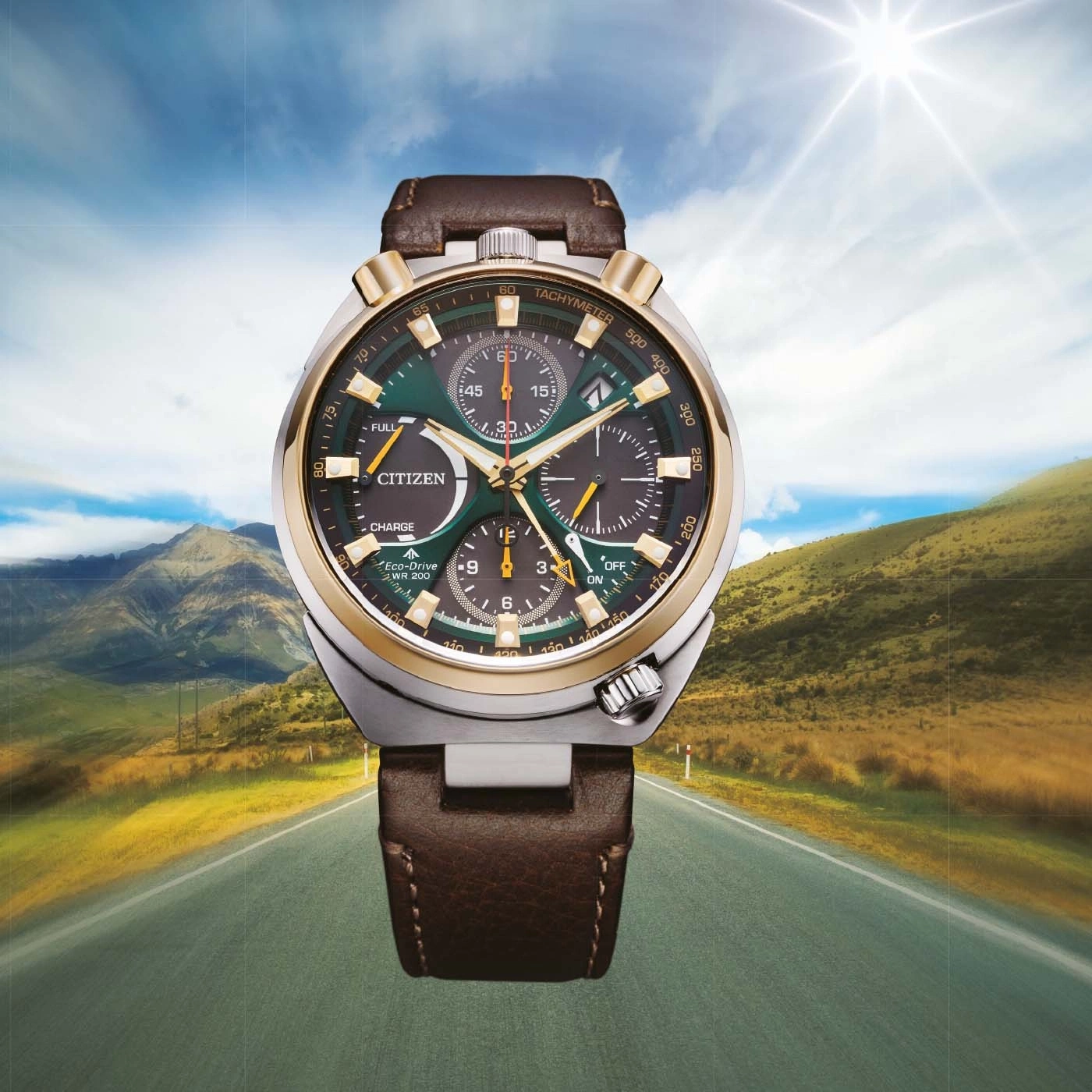Eine Citizen Eco-Drive Uhr auf einer landschaftlich reizvollen Straße mit Bergen und Sonne.