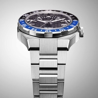 Nahaufnahme einer silbernen Uhr mit blau-schwarzer Lünette und Metallarmband.