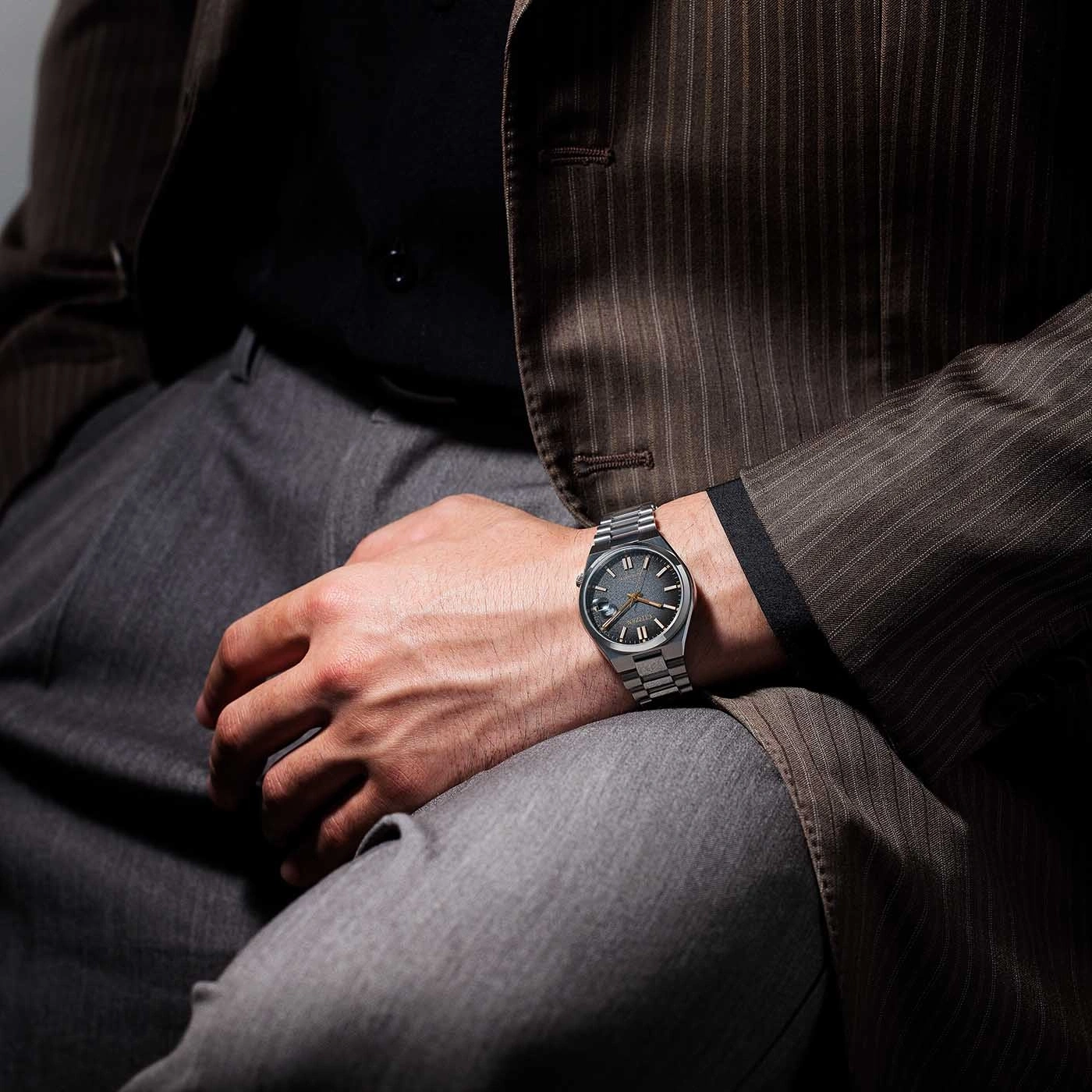 Mann mit Uhr, Anzug und Hose. Armbanduhr am Handgelenk, stilvoll gekleidet.
