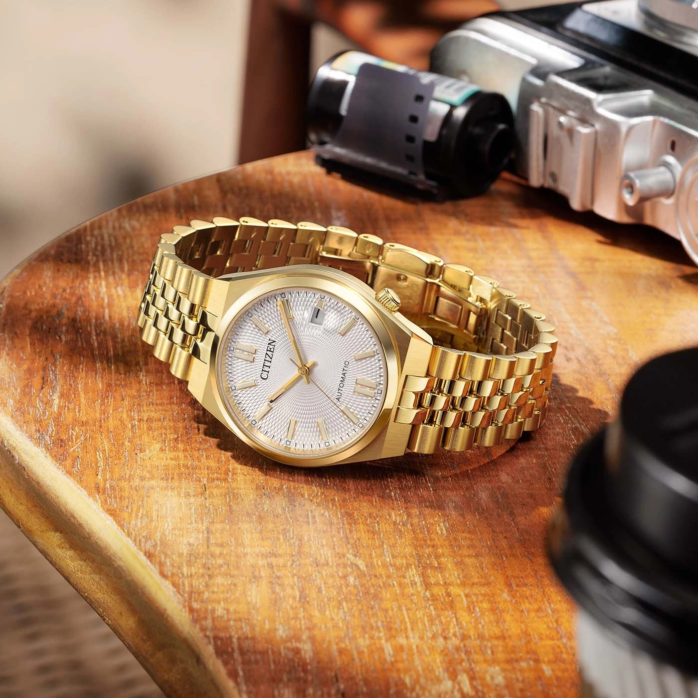 Goldene Citizen-Uhr mit Automatikwerk auf Holzoberfläche.