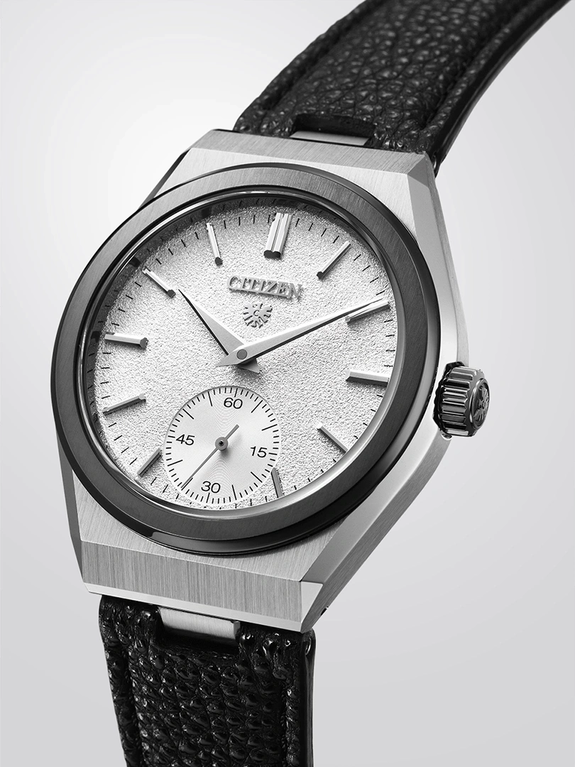 Citizen-Uhr mit strukturiertem silbernem Zifferblatt und schwarzem Lederarmband.