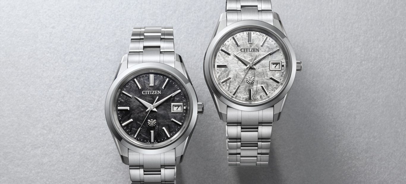 Two Citizen watches are featured, one with a dark textured dial, the other with a light textured dial, both with metal bracelets.