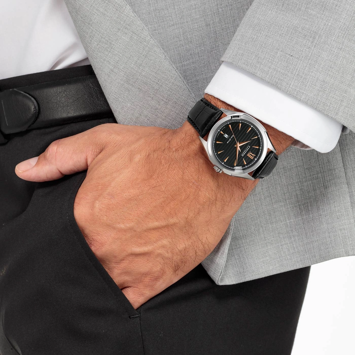 Mann mit Uhr, Anzug und schwarzer Hose, Hand in der Tasche.