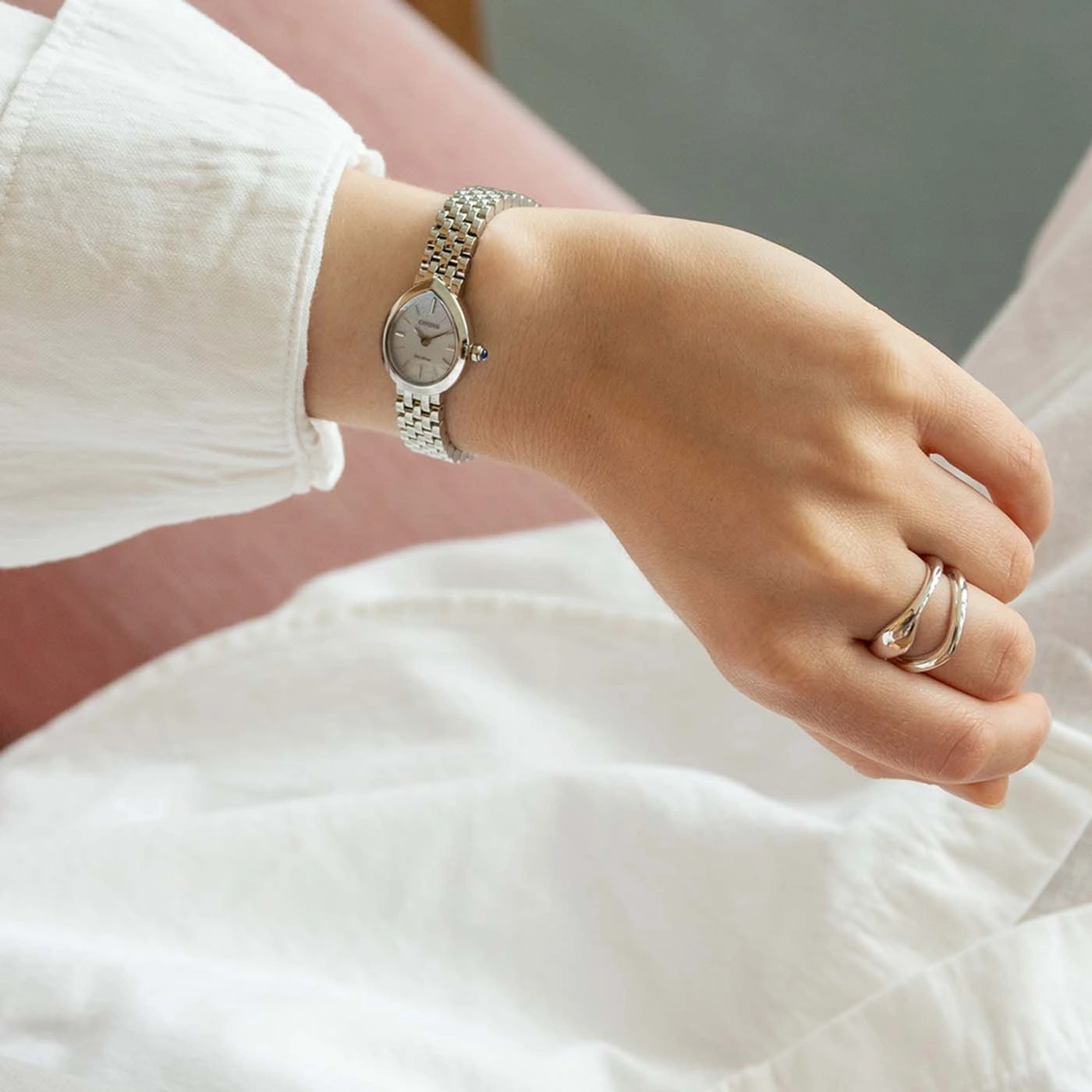 Eine Frauenhand mit einer silbernen Uhr und Ringen.