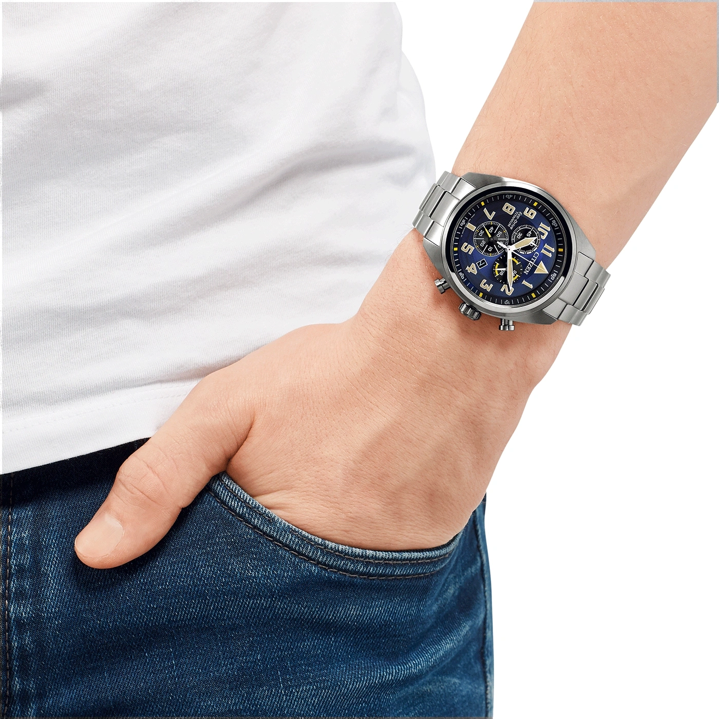 Mann trägt silberne Uhr mit blauem Zifferblatt, Hand in der Tasche.
