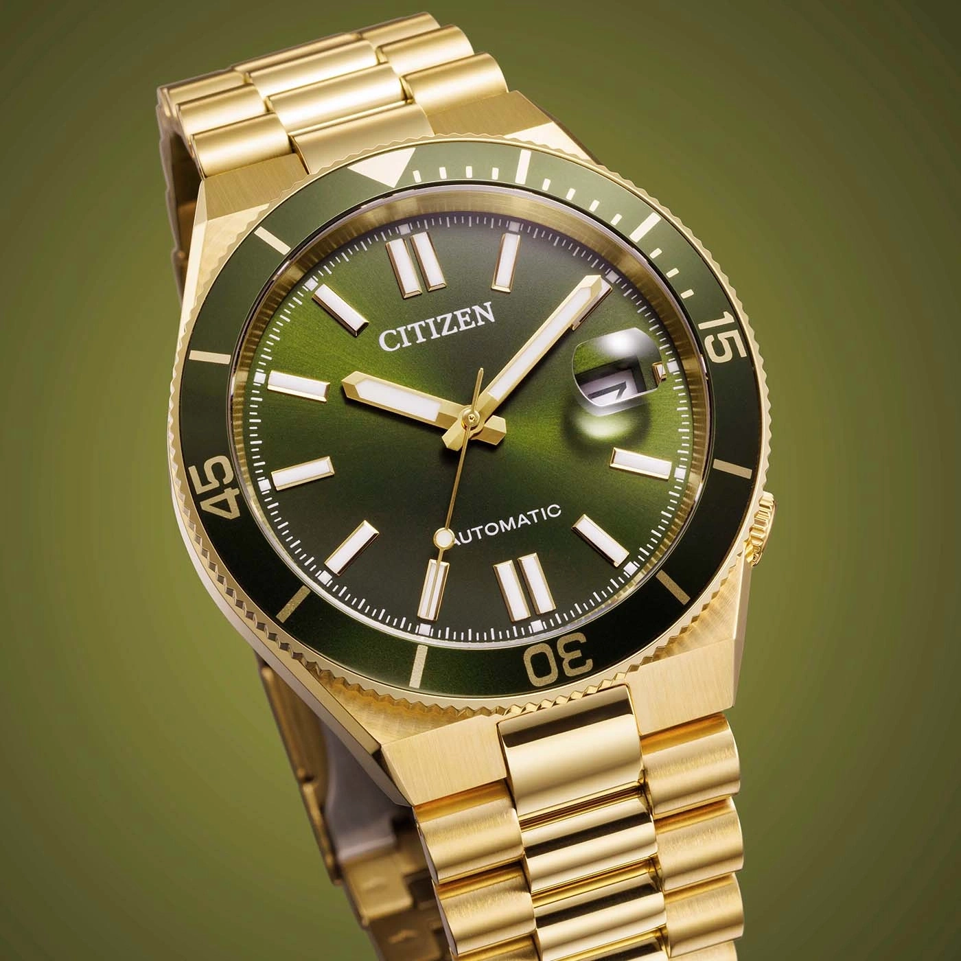 Eine goldene Citizen Automatik-Uhr mit grünem Zifferblatt und Lünette.