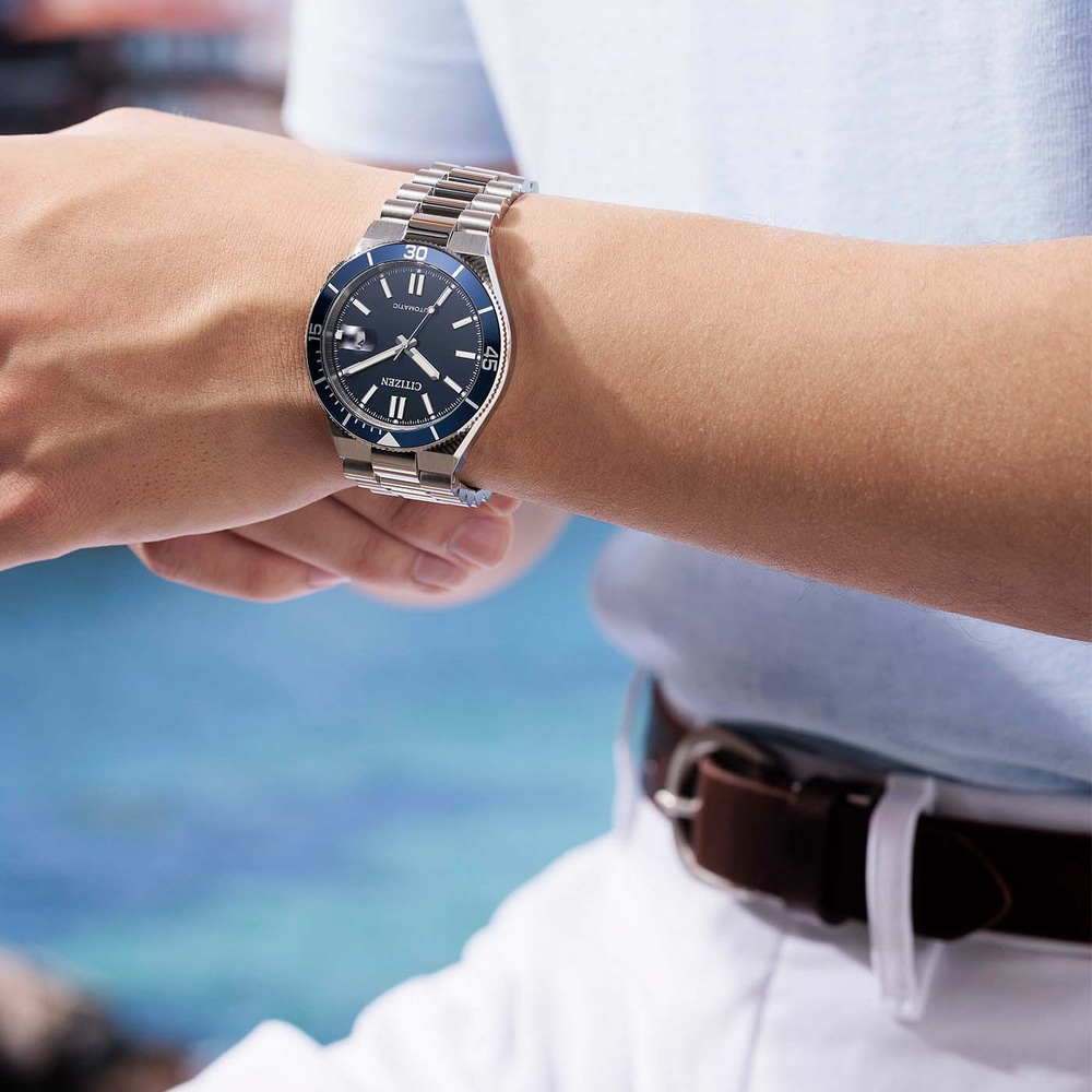 Mann trägt eine Citizen Automatik-Uhr mit blauem Zifferblatt am Handgelenk.