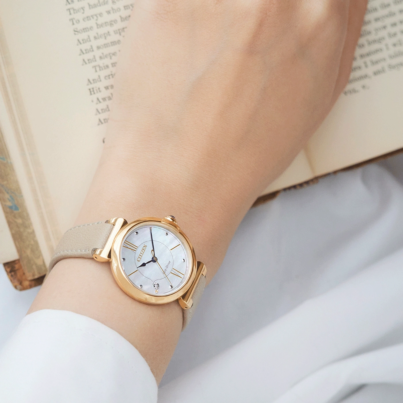 Armbanduhr am Handgelenk, goldene Uhr mit hellbraunem Armband, Citizen Uhr.