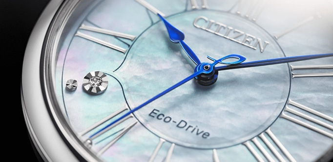 Nahaufnahme einer Citizen Eco-Drive Uhr mit blauen Zeigern und römischen Ziffern.