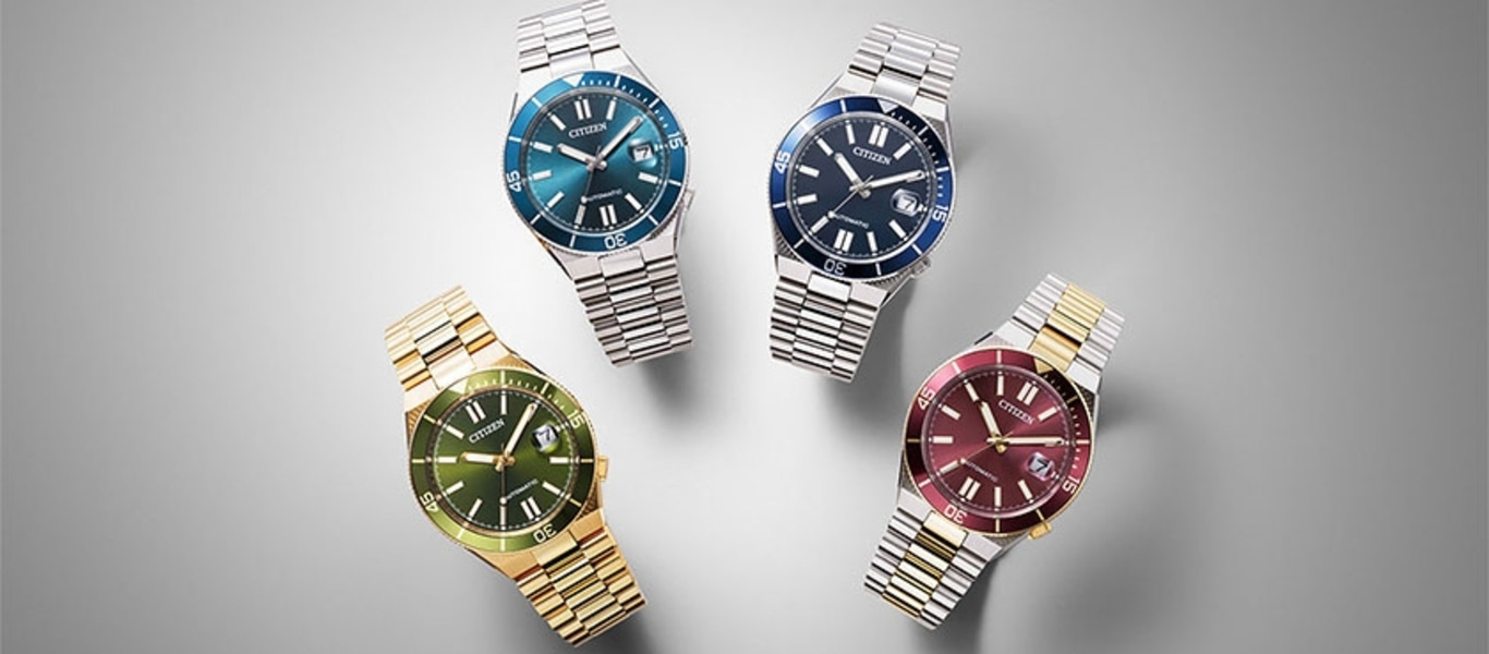 Vier Citizen-Uhren mit unterschiedlich farbigen Zifferblättern und Metallarmbändern.