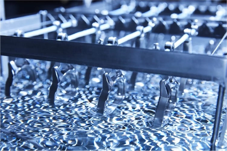 Metallteile werden in Flüssigkeit getaucht, industrieller Prozess, Nahaufnahme.