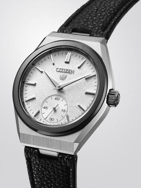 This image features a Citizen watch with a silver-toned case, textured white dial, and black strap, on a reflective surface.