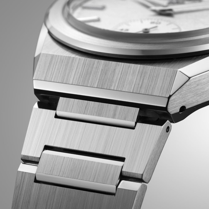 This close-up image highlights the brushed and polished finishes of a watch's integrated metal bracelet and case. The precise alignment of the links and the sharp angles of the case reveal the high-quality craftsmanship and sophisticated design.