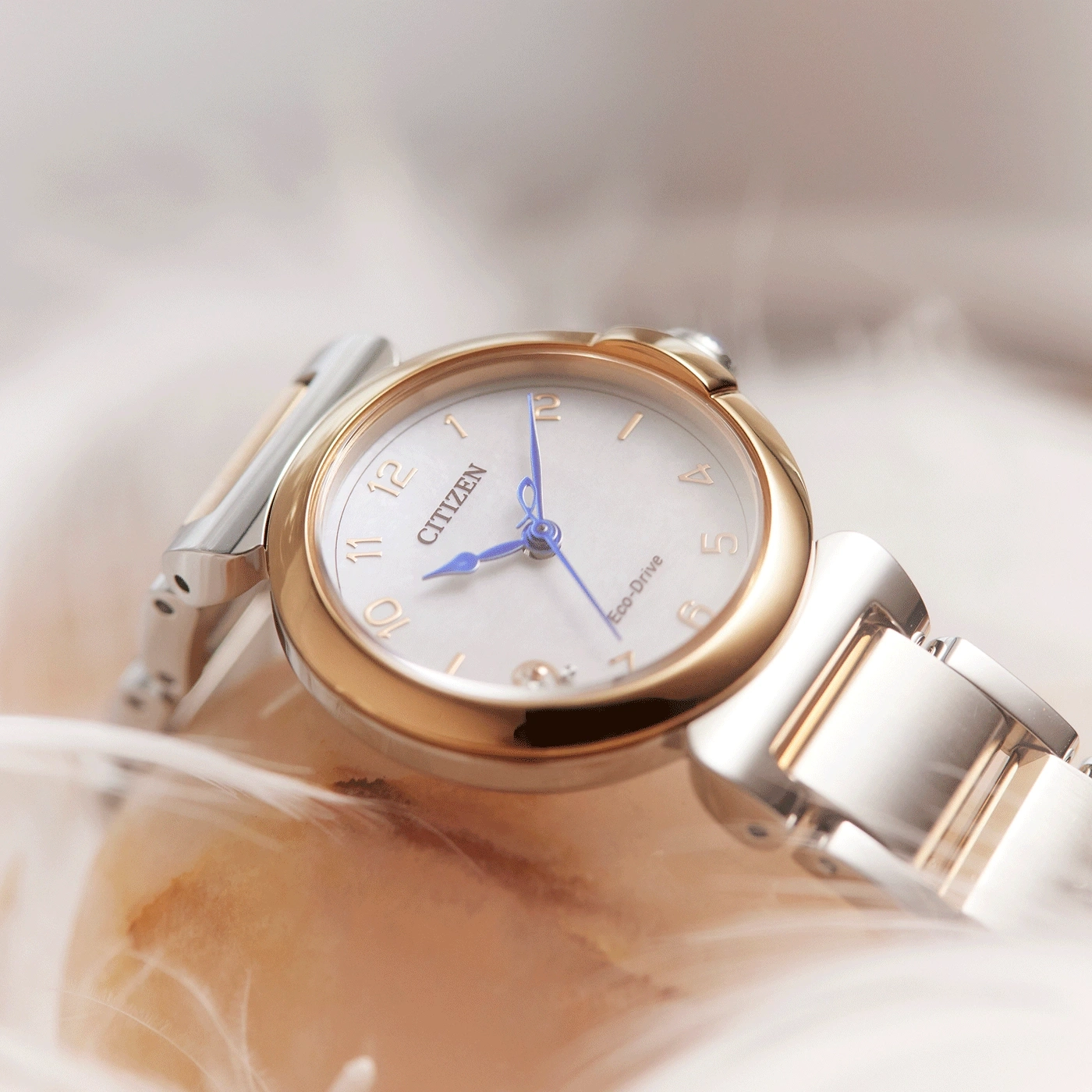 Citizen Eco-Drive Uhr mit Gold- und Silberakzenten auf weichem Hintergrund