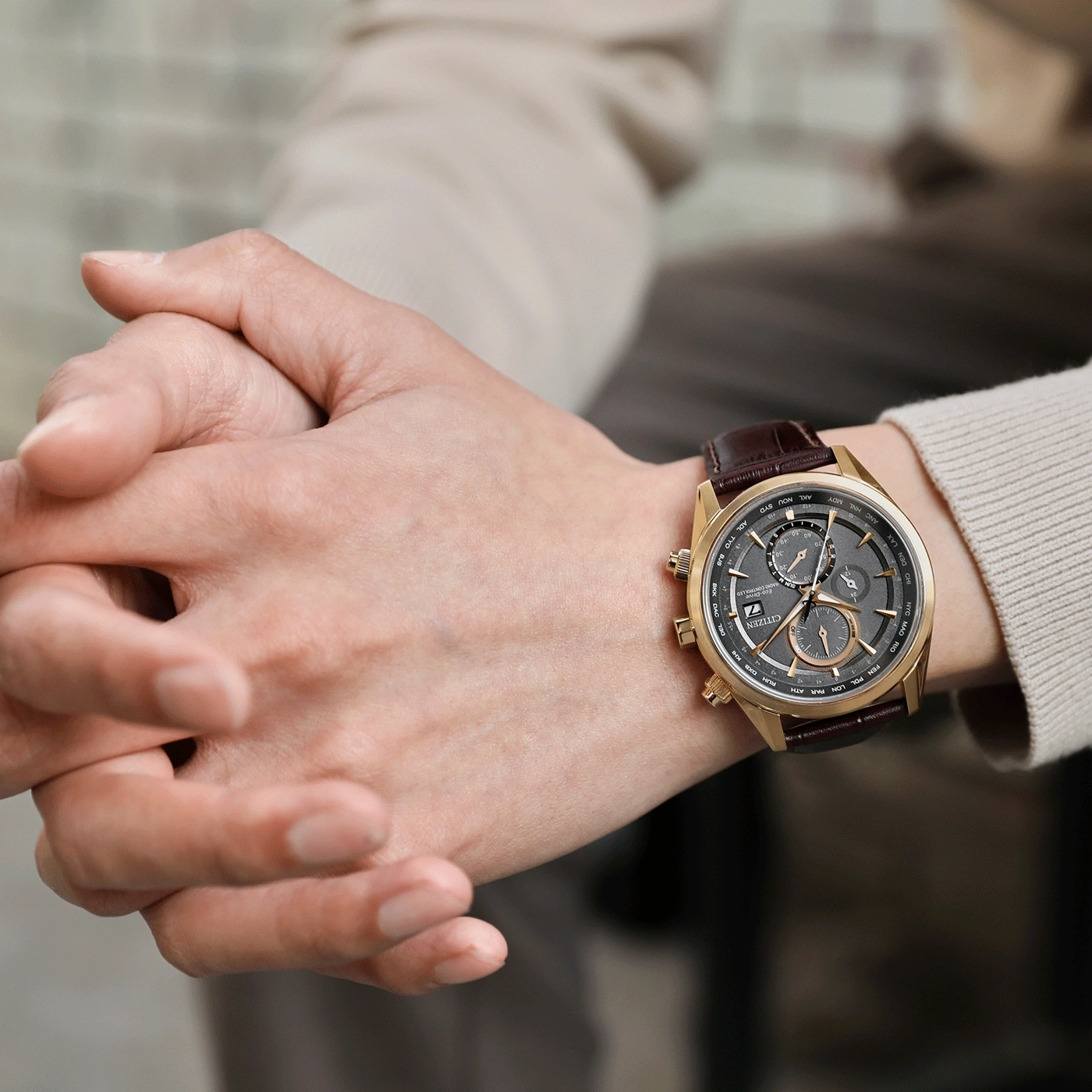 Mann trägt goldene Citizen-Uhr mit braunem Lederarmband am Handgelenk