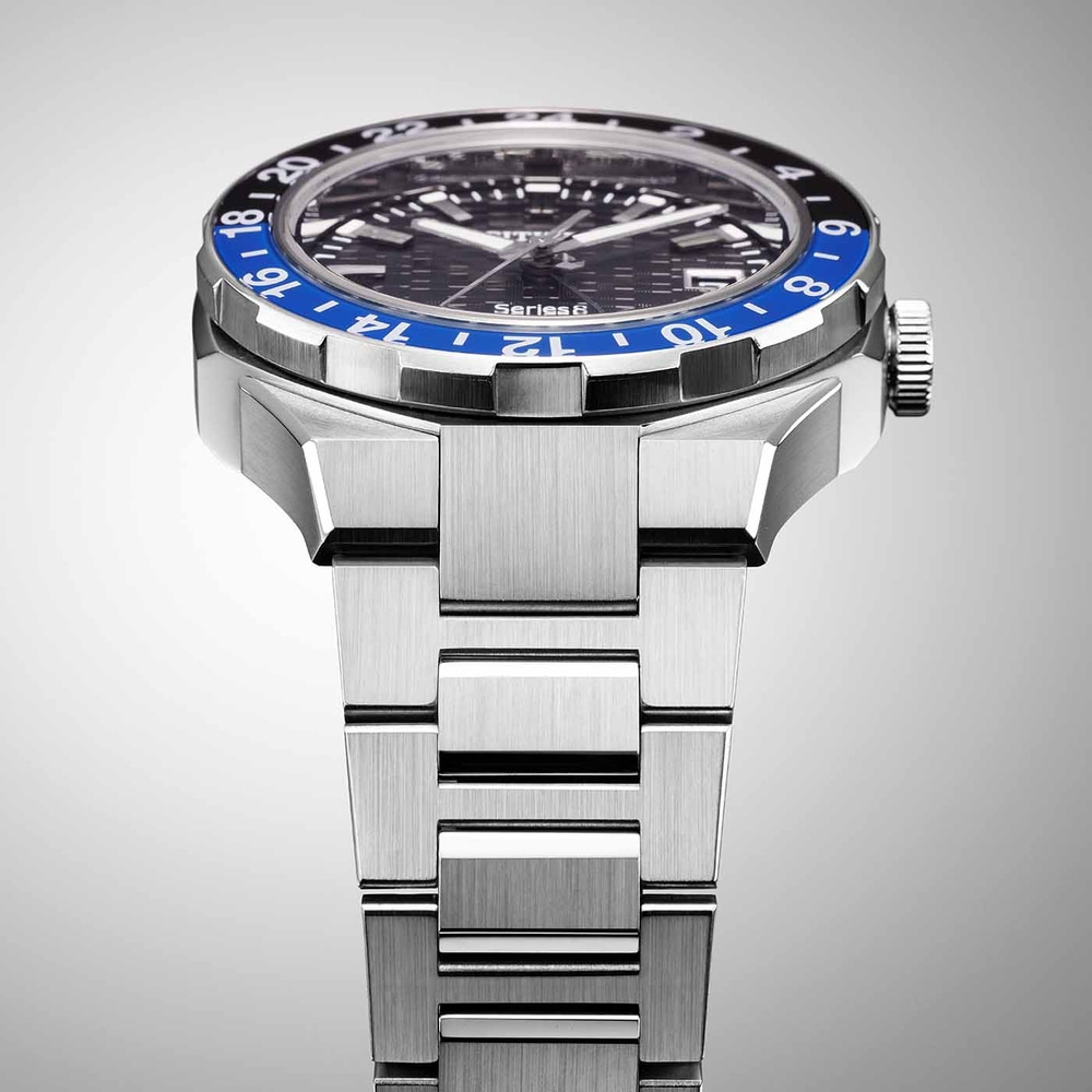 Nahaufnahme einer silbernen Uhr mit blau-schwarzer Lünette und Metallarmband.