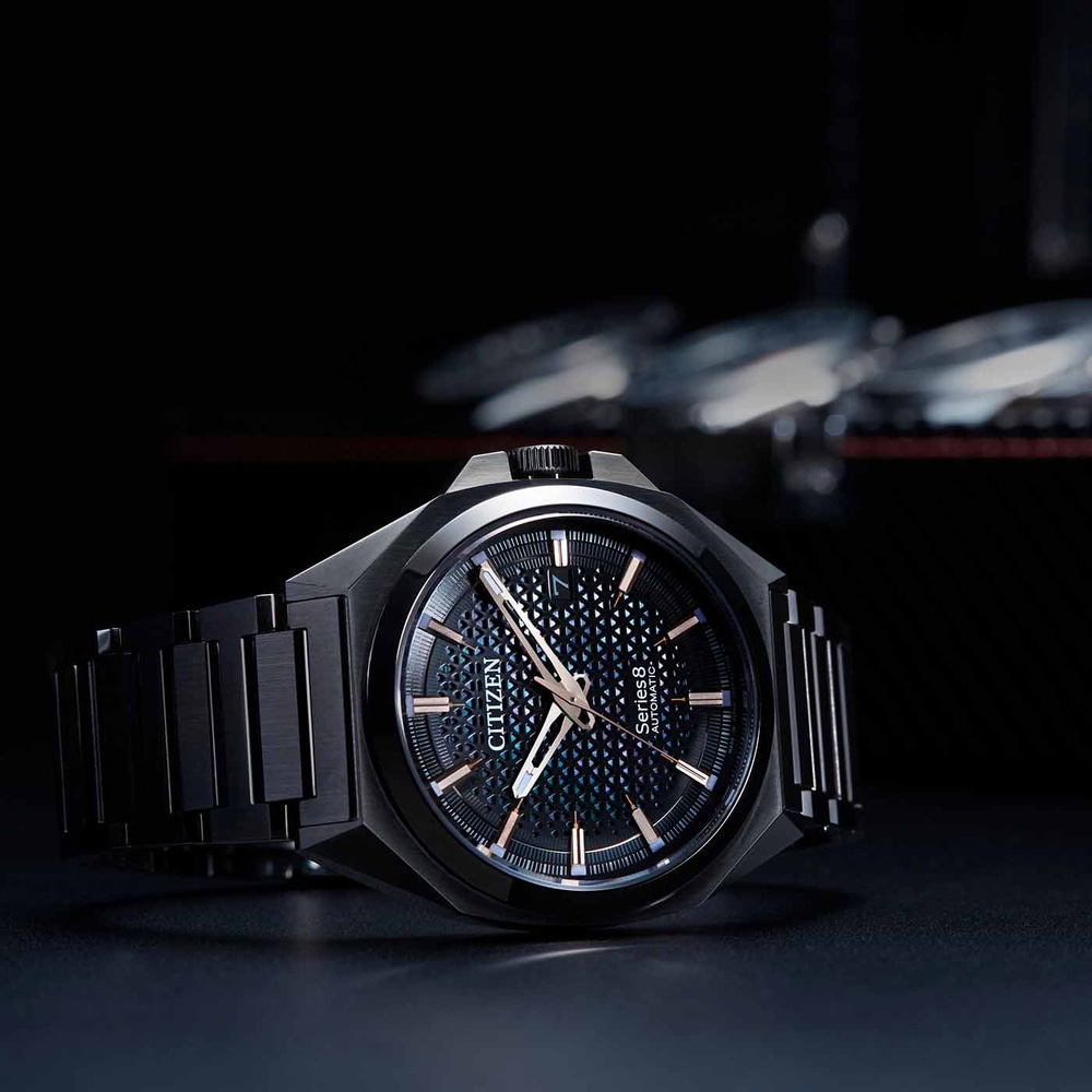 Schwarze Citizen-Uhr mit gemustertem Zifferblatt und schwarzem Armband.