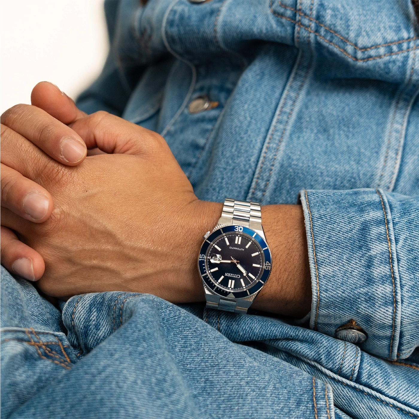 Mann trägt eine Jeansjacke und eine Citizen-Uhr