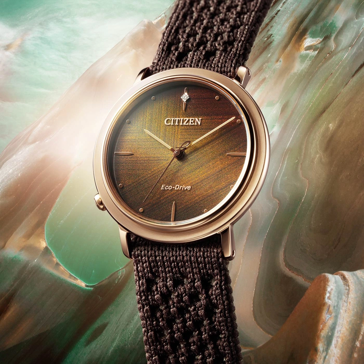 Citizen-Uhr mit braunem Armband und goldenem Zifferblatt.