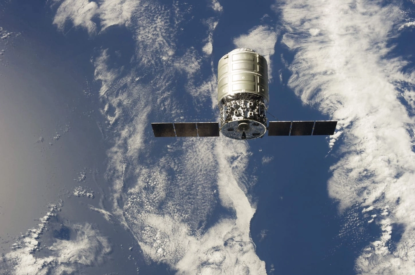Raumschiff im Orbit über der Erde mit Sonnenkollektoren und Wolken im Hintergrund.