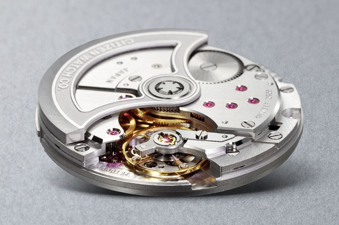 This close-up showcases a meticulously crafted Citizen watch movement. Polished metal bridges, visible rubies, and intricate gears are precisely arranged, revealing the complex mechanical heart and exceptional engineering.
