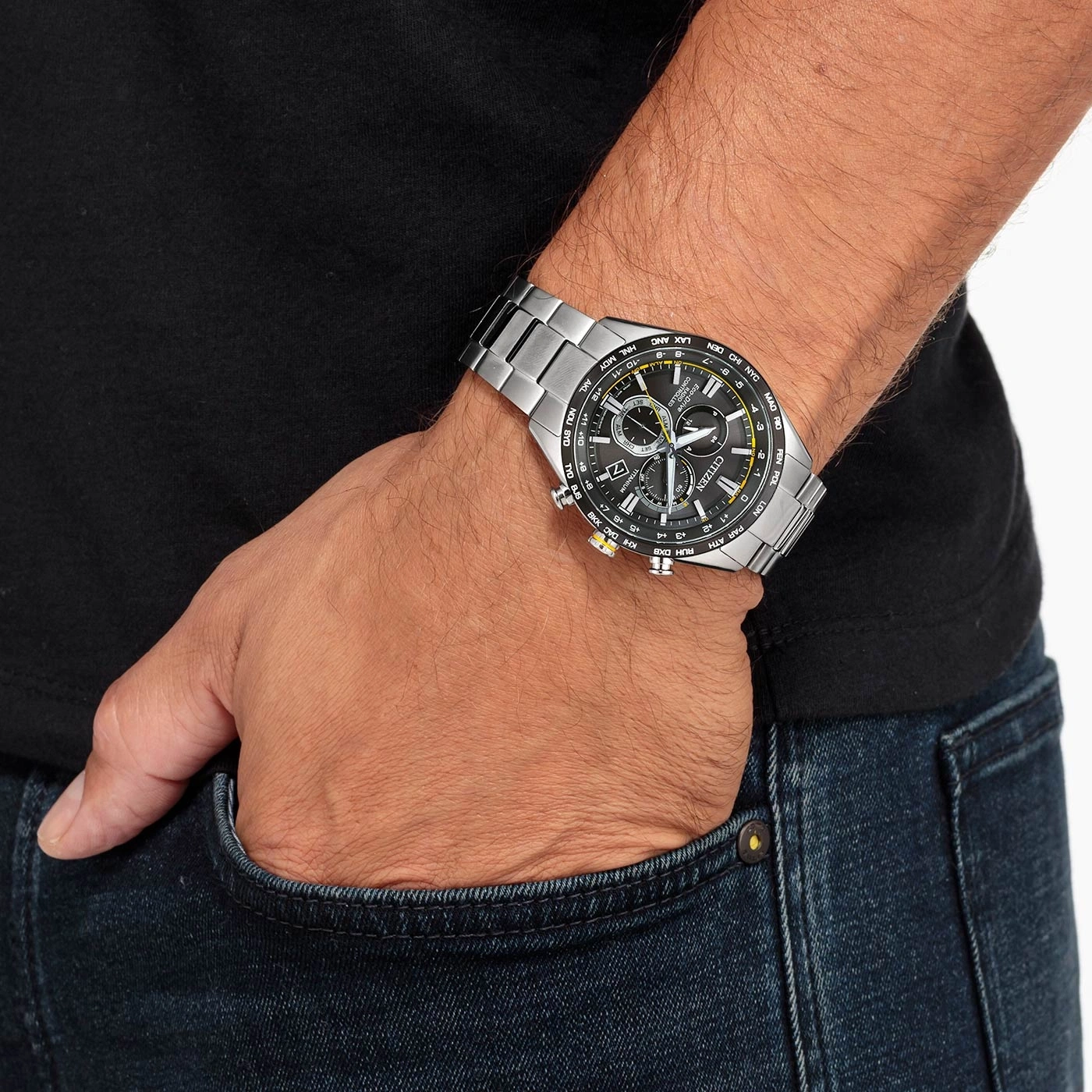 Mann mit Citizen-Uhr, schwarzem Hemd und Jeans. Hand in der Tasche.